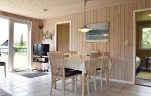uma sala de jantar com uma mesa e cadeiras e uma televisão em Beautiful Home In Vemb With Wifi em Thorsminde