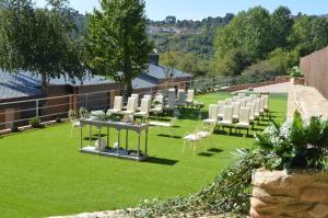 a group of white chairs and tables on a lawn at Hotel Calzada in Arcos
