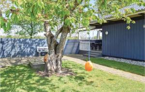 an orange swing hanging from a tree in a yard at Holiday Home Pøt Strandby Juelsminde Ix in Sønderby