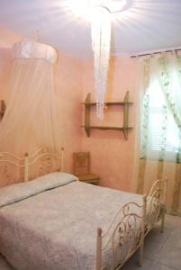 1 dormitorio con cama y lámpara de araña en Fantasy House Ischia, en Isquia