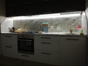 a kitchen with a sink and a stove top oven at MANGO- апартаменты БЕЛЫЕ НОЧИ в Кобрине in Kobryn