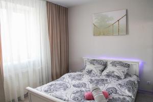 a bedroom with a bed with a white and black comforter at MANGO- апартаменты БЕЛЫЕ НОЧИ в Кобрине in Kobryn