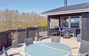 un patio con mesa y sillas en una terraza en Awesome Home In Kirke Hyllinge With Kitchen en Kirke-Hyllinge