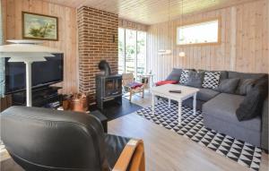 uma sala de estar com um sofá e uma lareira em Nice Home In Thyholm With 3 Bedrooms And Wifi em Thyholm