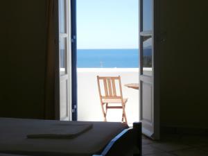 a room with a view of the ocean and a chair at Galini Bungalows in Kionia