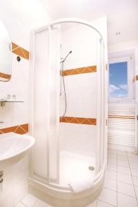 a white bathroom with a shower and a sink at Pension PRIMUS in Beroun