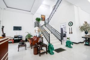 una sala de estar con muebles y una escalera. en RedDoorz Syariah At Lampung Walk, en Bandar Lampung