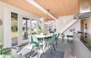 a dining room with a table and green chairs at Holiday Home Mimosavej Ebeltoft Iii in Ebeltoft
