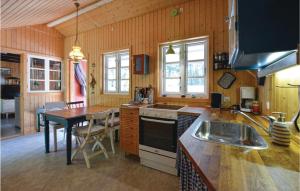 uma cozinha com uma mesa e um fogão forno superior em Awesome Home In Hjby With Kitchen em Højby