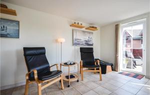 a living room with two chairs and a table at Amazing Home In Rm With House Sea View in Bolilmark