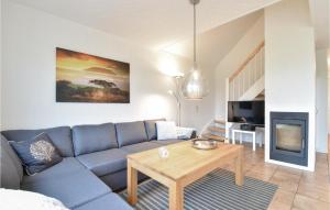 ein Wohnzimmer mit einem blauen Sofa und einem Tisch in der Unterkunft 3 Bedroom Beautiful Home In Brenderup Fyn in Bro