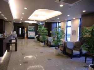 a lobby with a waiting room with potted plants at Hotel Route-Inn Oyama in Oyama