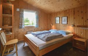 HemmetにあるNice Home In Tarm With 3 Bedroomsの木製の部屋にベッド1台が備わるベッドルーム1室があります。