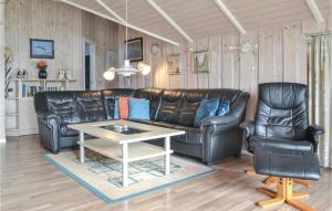 a living room with a leather couch and two chairs at Beautiful Home In Fan With Kitchen in Fanø