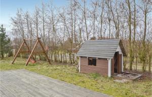 una casa pequeña y un parque infantil con un columpio en Stunning Home In Fan With 4 Bedrooms, Sauna And Wifi, en Fanø