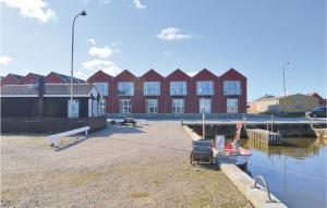 um edifício vermelho com um edifício ao lado da água em 2 Bedroom Amazing Home In Ulfborg em Thorsminde