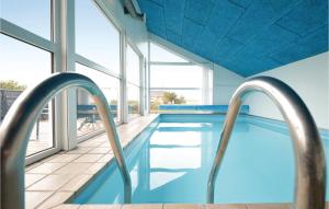 a swimming pool with two metal rails in a building at Amazing Home In Ebeltoft With Sauna, Wifi And 4 Bedrooms in Ebeltoft