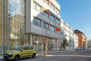 um pequeno carro verde estacionado em frente a um edifício em Centro Hotel Celler Tor em Braunschweig