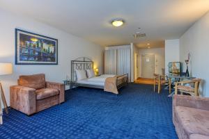 ブラウンシュヴァイクにあるセントロホテル セラートールのベッドルーム1室(ベッド1台、椅子、テーブル付)