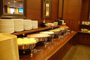 una linea a buffet con piatti e ciotole di cibo di Hotel Route-Inn Tsuruga Ekimae a Tsuruga