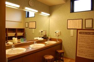 un bagno con due lavandini e un grande specchio di Hotel Route-Inn Tsuruga Ekimae a Tsuruga