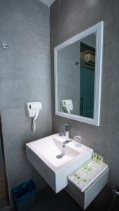 W łazience znajduje się biała umywalka i lustro. w obiekcie Hotel 99 Sepang KLIA & KLIA2 w mieście Sepang