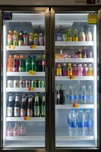 a refrigerator filled with lots of different types of drinks at NK Garden Hotel @Suratthani Airport in Surat Thani