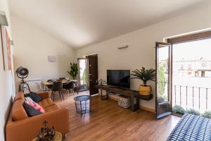 Sala de estar con sofá, TV y mesa en Mi Villa Arévalo, en Arévalo