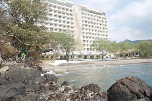 a large white building next to a beach at Louis Kienne Resort Senggigi in Senggigi