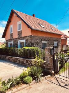 ein Backsteinhaus mit einem Zaun davor in der Unterkunft Tihany Levendula Villa in Tihany