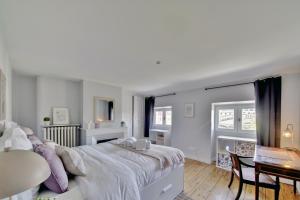 biała sypialnia z dużym łóżkiem i stołem w obiekcie Le Joyau by Cocoonr w mieście Bordeaux
