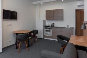 ein Wohnzimmer mit Tisch und Stühlen und eine Küche in der Unterkunft Muontis in Šilalė