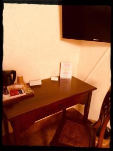 a wooden desk with a television on a wall at AGRITURISMO RIPA DEL BOSCO in Capriolo