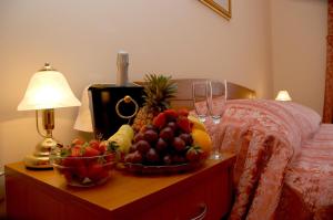 una mesa con un bol de frutas y copas de vino en ApartHotel Villa Mozart, en Podgora