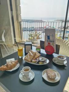una mesa con platos de repostería y tazas de café en B & B San Giovanni 9, en Gallipoli