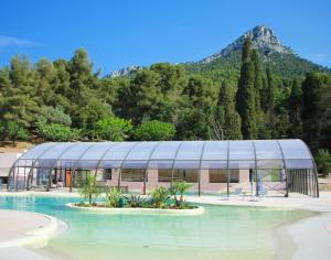 un bâtiment en verre avec une montagne en arrière-plan dans l'établissement Domaine des Gueules Cassees, à La Valette-du-Var