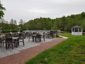 un patio con mesas y sillas y un cenador en Der Quellenhof en Helmstedt