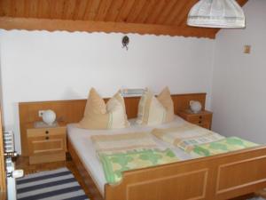 Schlafzimmer mit einem großen Bett mit einem Kopfteil aus Holz in der Unterkunft Ferienhaus Warmuth in Sankt Stefan an der Gail