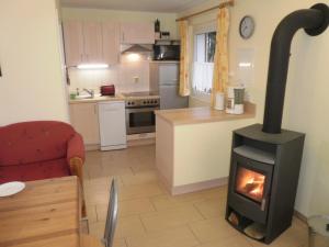 a living room with a stove in a kitchen at Canow in Canow