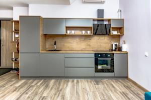 a kitchen with gray cabinets and a wooden floor at Golden Beach in Šventoji +12 photos