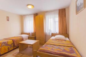 um pequeno quarto com duas camas e uma mesa em Zolotaya Bukhta em Svetlogorsk