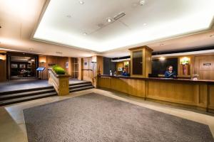 a hotel lobby with a woman standing at a counter at Glasgow West Hotel by Compass Hospitality in Glasgow