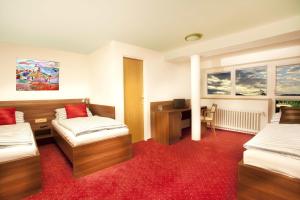 um quarto de hotel com duas camas e uma secretária em Pension PRIMUS em Beroun