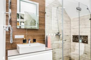uma casa de banho com um lavatório e um chuveiro em Golden Beach em Šventoji