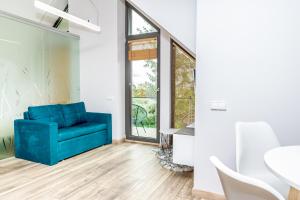 a living room with a blue couch and a table at Golden Beach in Šventoji