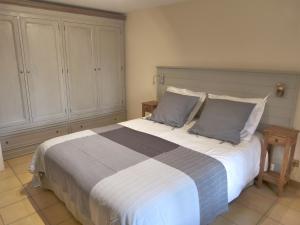 ein Schlafzimmer mit einem großen Bett mit zwei Kissen in der Unterkunft Villa Thebaïde Chambres d'hôtes in Laudun