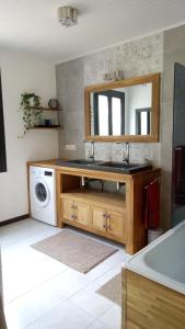 uma casa de banho com um lavatório e uma máquina de lavar roupa em Les SenS de l'Escalette em Pégairolles-de-lʼEscalette