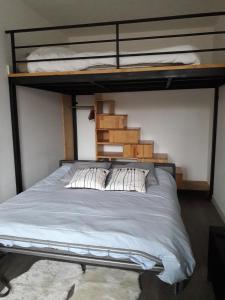 a bedroom with a bunk bed with white sheets and pillows at Studio Molinel in Lille