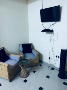 a living room with two chairs and a television at Le Paradis Nyali in Mombasa