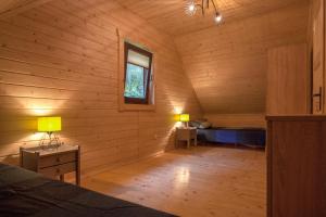 a room with a bed and a window in a log cabin at Bieszczadzka Zatoka in Zawóz